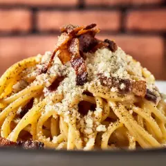 Pyszne włoskie dania z makaronem, jak Carbonara, z chrupiącym boczkiem i parmezanem.