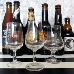 Kolekcja butelek i kieliszków do degustacji, prezentująca różnorodne gatunki piwa w Polsce.