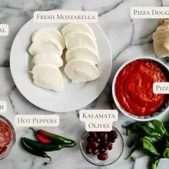 Składniki na pizzę z salami: ciasto, sos, mozzarella, oliwki, papryczki, bazylia i mąka kukurydziana.