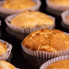 Złociste muffinki jogurtowe w papierowych foremkach, gotowe do schrupania.