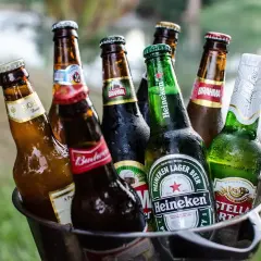 Wiadro pełne butelek z orzeźwiającym, jasnym piwem, gotowe na letnie popołudnie.