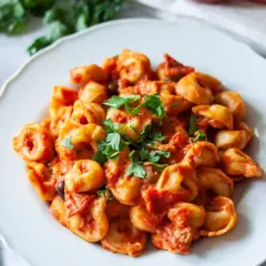 Pyszne tortellini w sosie pomidorowym z oliwkami i natką pietruszki. Idealne na szybki obiad, a przepis jest prosty!