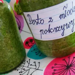 Dwa słoiki domowego pesto z młodej pokrzywy, gotowe do przechowywania.