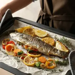 Pyszny filet z pstrąga z piekarnika, pieczony z cytryną, warzywami i ziołami.