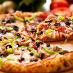 Pyszna pizza na spodzie do pizzy, z ciągnącym serem, oliwkami, papryką i salami. Idealna na spotkanie z przyjaciółmi.