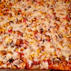 Pyszne ciasto na pizzę włoską z kurczakiem, kukurydzą i pieczarkami, zapieczone pod grubą warstwą sera.