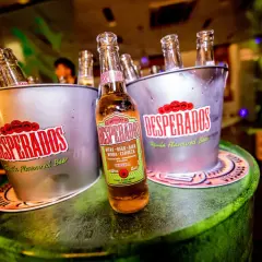 Butelki Desperados w wiaderkach, jedna z nich pokazuje zawartość alkoholu 5,9% vol.