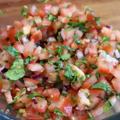 Świeża salsa pico de gallo z pomidorów, cebuli i kolendry w szklanej misce. Idealna do nachos!