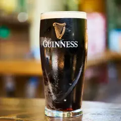 Szklanka Guinnessa, ciemnego piwa z pianką, którego barwa i smak wynikają ze słodu jęczmiennego.
