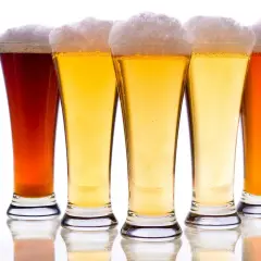 Pięć kielichów z piwem, w tym ciemny bursztynowy i jasny pilsner, z obfitą pianką.