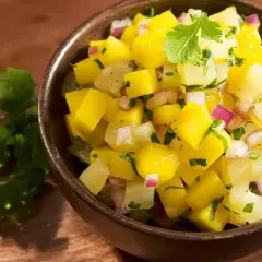 Miseczka pełna świeżej, kolorowej salsy mango z kawałkami mango, cebuli i kolendry. Idealna na letnie dni.