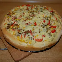 Domowa pizza z kukurydzą, papryką i pieczarkami, idealnie doprawiona. Zastanawiasz się, jakie przyprawy do pizzy wybrać?