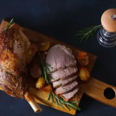 Pieczona noga jagnięca, idealna po marynowaniu mięsa, podana z ziemniakami i rozmarynem.