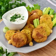 Chrupiące falafel na talerzu z sosem jogurtowym i warzywami. Idealny falafel przepis na szybką przekąskę.