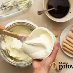 Kremowy serek mascarpone ląduje w misce, by stworzyć idealny deser. Obok kawa, biszkopty i mikser.