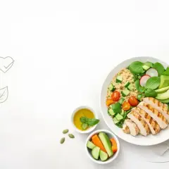 Zdrowe, mało kaloryczne dania: grillowany kurczak z komosą ryżową, awokado, pomidorkami i ogórkiem. Obok sos i warzywa.