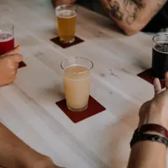 Ludzie świętują dzień piwa, delektując się różnymi rodzajami piwa przy drewnianym stole.