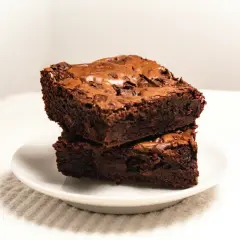 Dwa pyszne brownie, które Ania gotuje, ułożone na talerzyku.