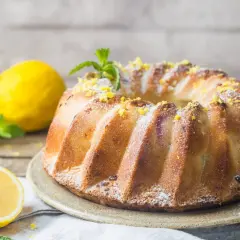 Złocista, pachnąca cytryną babka serowa, posypana cukrem pudrem i skórką cytrynową, z listkami mięty. To najlepsza babka serowa na świecie!