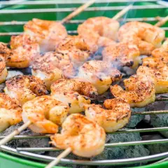 Krewetki marynata na grillu, dymiące i rumiane, gotowe do podania.