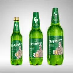 Trzy zielone butelki piwa Edelmeister Pilsener, jedna mniejsza, dwie większe, pokryte kroplami rosy.