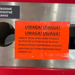 Ostrzeżenie przed wrzucaniem uszkodzonych butelek po piwie do automatu. Maszyna jest monitorowana przez kamery.