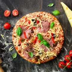 Gotowa pizza z salami i serem, obok wałek, pomidorki i ser. Idealna do domowego wypieku, zastanawiasz się, jaka mąka do pizzy domowej będzie najlepsza?