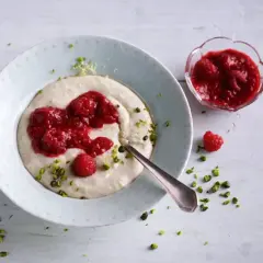 Puszysta kasza manna z malinowym musem i posiekanymi pistacjami. Idealne śniadanie pełne smaku.
