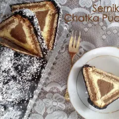 Sernik Chatka Puchatka, udekorowany czekoladą i wiórkami kokosowymi, wygląda pysznie. Kawałek na talerzyku zachęca do spróbowania.
