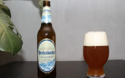 Butelka i szklanka z piwem Perlenbacher Hefeweissbier. Idealne piwa pszeniczne na relaks.