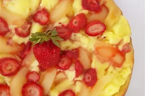 Słodka pizza z kremem budyniowym, truskawkami i kawałkami gruszek. Idealna na deser.