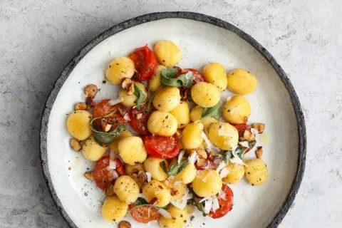 Gnocchi z pomidorkami, szałwią i orzechami. Prosty przepis na gnocchi z czym podawać, by zachwycić smakiem.