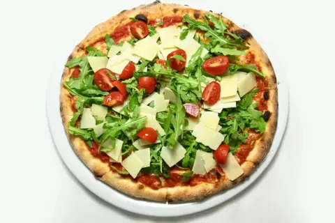Pizza z rukolą i pomidorkami, z płatkami parmezanu. Świetna opcja, co zamiast sera na pizzy, gdy chcesz czegoś lżejszego.