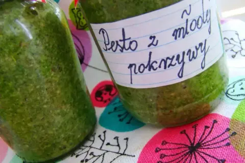 Dwa słoiki domowego pesto z młodej pokrzywy, gotowe do przechowywania.