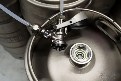 Metalowy piwo keg z podłączonym kranikiem i rurką. Gotowy do nalewania orzeźwiającego napoju.