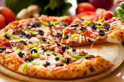 Pyszna pizza z serem, oliwkami i papryką, idealna na światowy dzień pizzy.