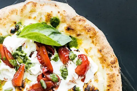 Pyszna pizza na diecie z pomidorami, mozzarellą i pesto. Lekka i zdrowa, idealna na letni wieczór.