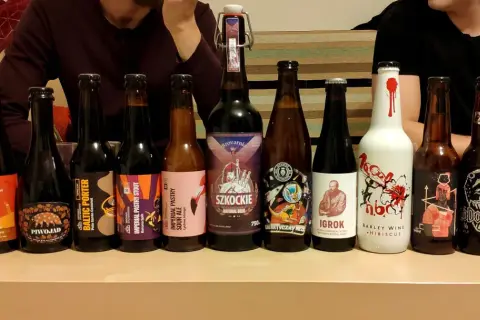Rząd butelek z piwem, w tym mocne piwo, z etykietami "Piwojad", "Baltic Porter", "Imperial Pastry Stout", "Szkockie", "Igroki" i "Perła".