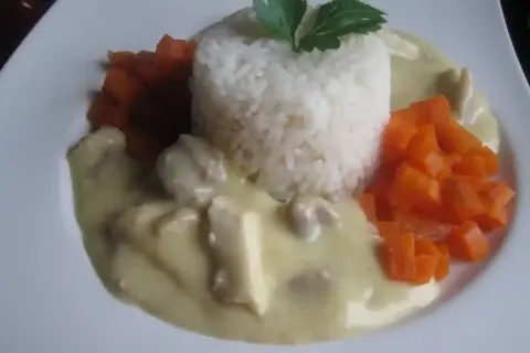 Pyszna potrawka z kurczaka w kremowym sosie, podana z ryżem i marchewką. Idealny sos do potrawki, który zachwyci każdego.