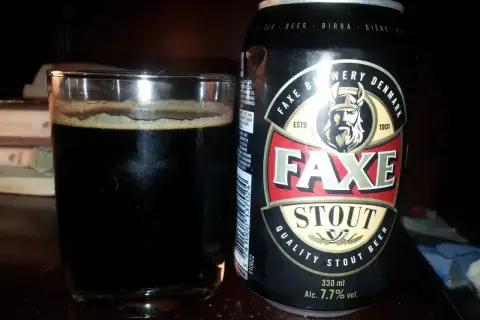Szklanka ciemnego piwa Faxe Stout obok puszki. To piwo 2 procent, idealne na wieczór.