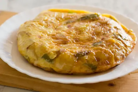 Złocista tortilla ziemniaczana z papryką na talerzu. Idealne śniadanie bez chleba, sycące i pyszne.