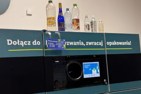 Na automacie do zwrotu opakowań stoją puste butelki. Widać, które butelki są zwrotne po piwie i innych napojach.