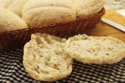Puszyste bułki bezglutenowe, idealne na śniadanie, leżą w koszyku i na czarno-białej kratce.