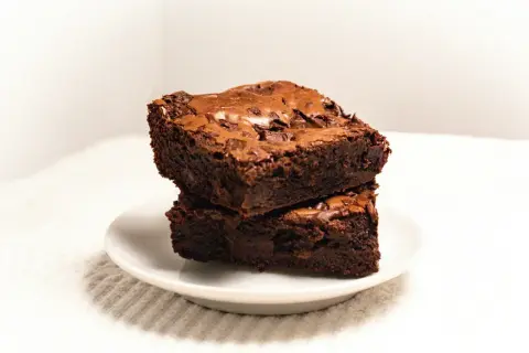 Dwa pyszne brownie, które Ania gotuje, ułożone na talerzyku.