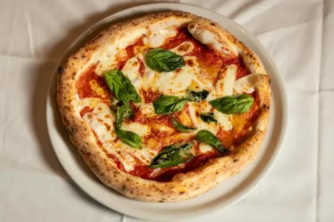 Margherita pizza z bazylią i mozzarellą. Czy wiesz, że ciekawostki o pizzy są równie pyszne jak ona sama?