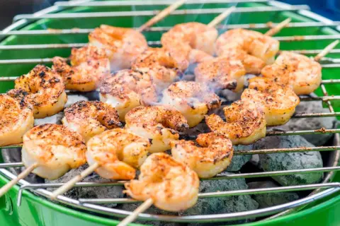 Krewetki marynata na grillu, dymiące i rumiane, gotowe do podania.