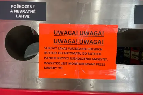 Ostrzeżenie przed wrzucaniem uszkodzonych butelek po piwie do automatu. Maszyna jest monitorowana przez kamery.
