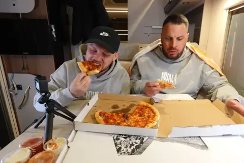 Dwóch mężczyzn je pizzę, jeden z nich próbuje najostrzejszej pizzy w Polsce.