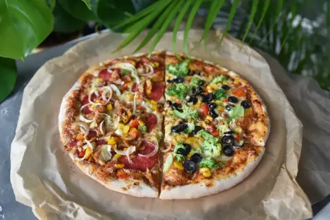 Imponująca pizza 100cm podzielona na pół: jedna strona z kurczakiem i warzywami, druga z brokułami i oliwkami.