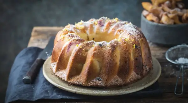 Szybka babka wilgotna, udekorowana skórką cytrynową i cukrem pudrem, kusi apetycznym wyglądem. Idealna na deser.